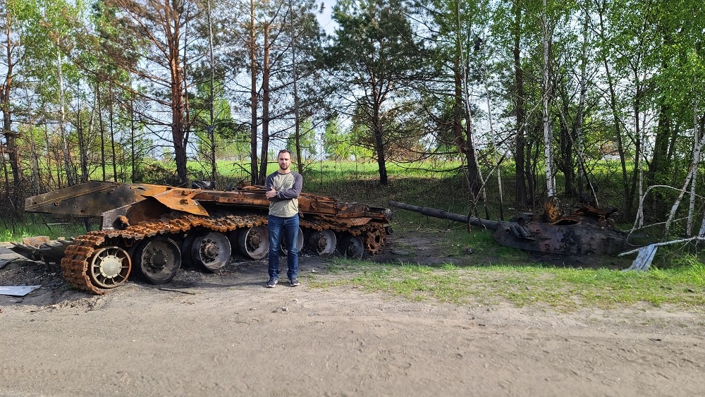 Michael in front of old military equipment