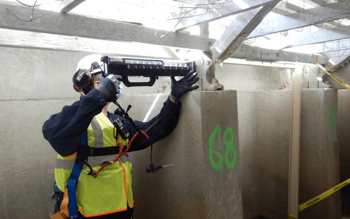 Resistograph drilling being performed on the primary timber support column to identify areas of internal rot and assess the relative density of the timber.